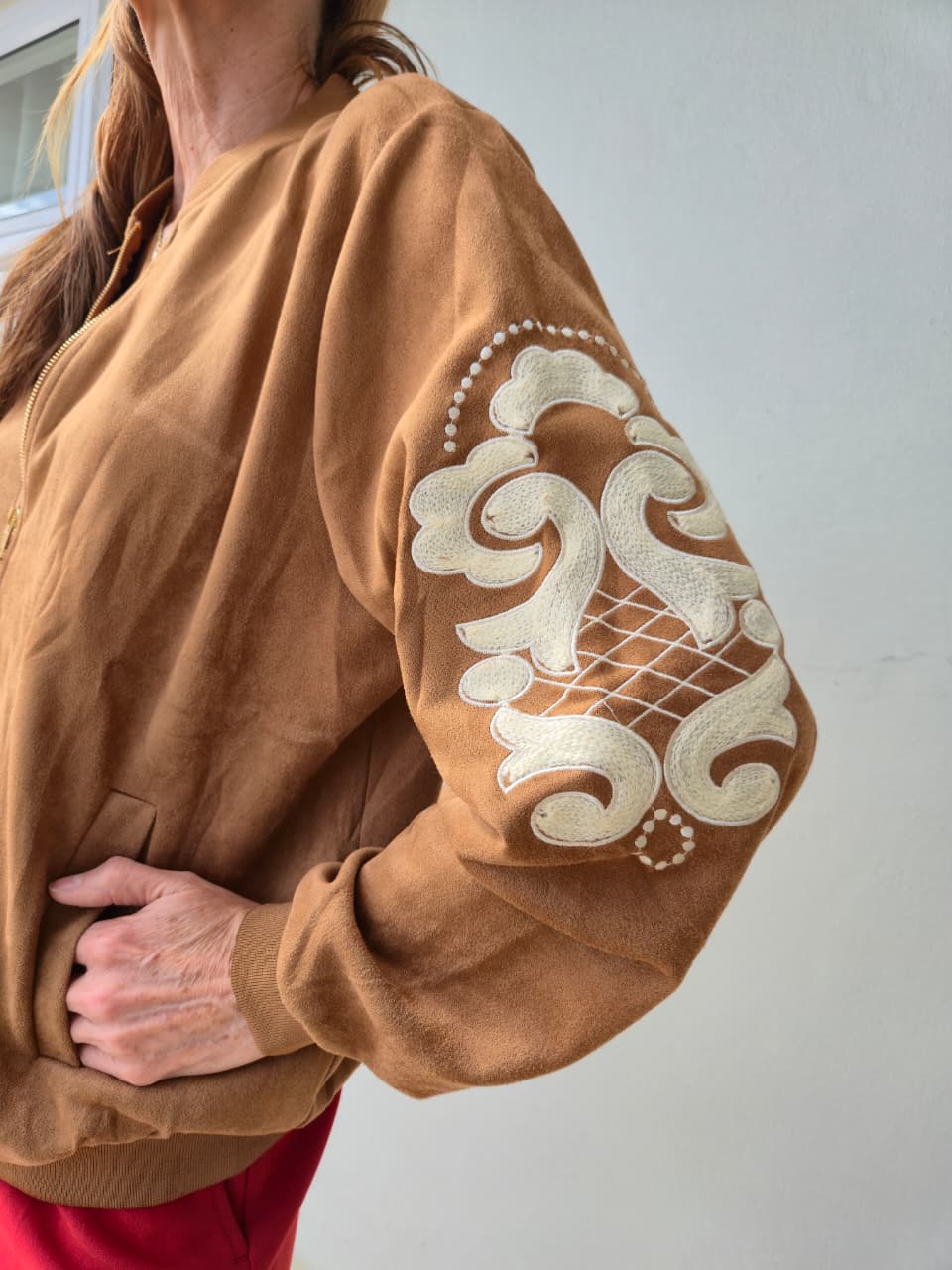 Suede feel bomber jacket with embroidered detail on the sleeves, elasticated cuff and side pockets.
