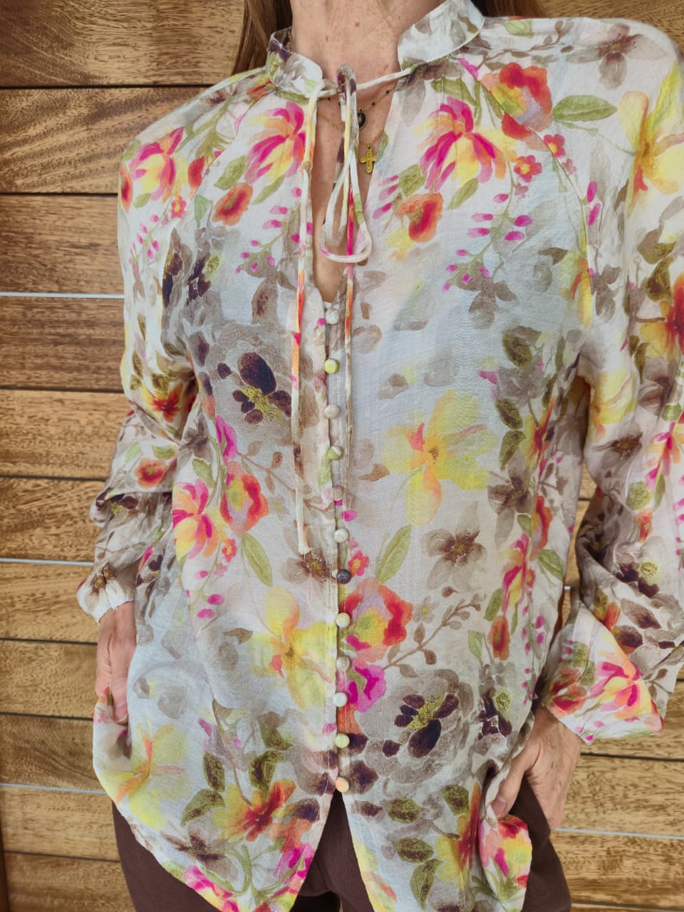 Sheer floral blouse on cream background with button/loop detail and elasticated cuff.