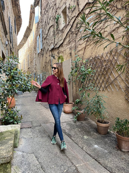 Kntted cape in Bordeaux with metal stud closures on the front.