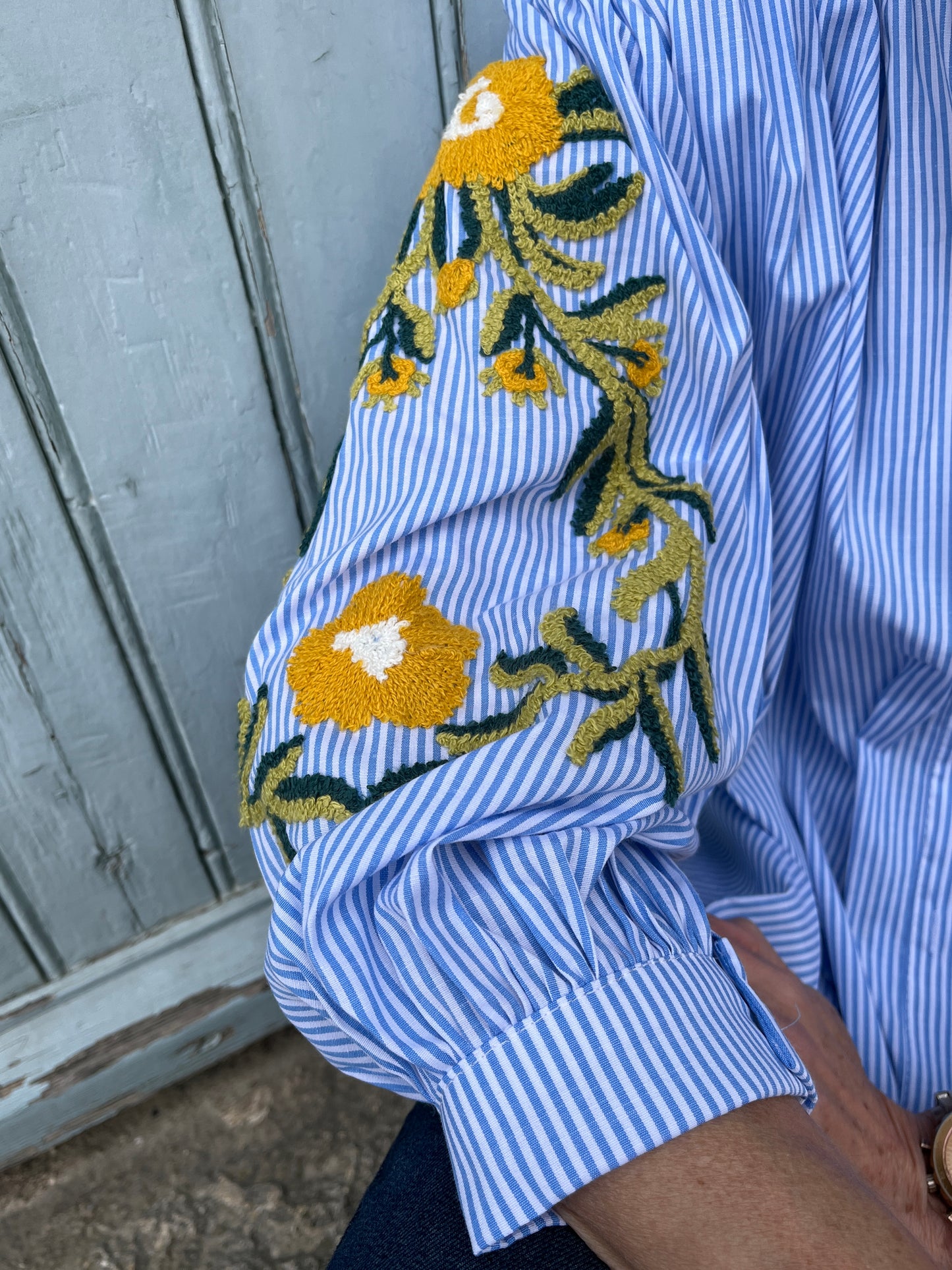 Button down oversize blue/white striped shirt with embroidered sleeves.