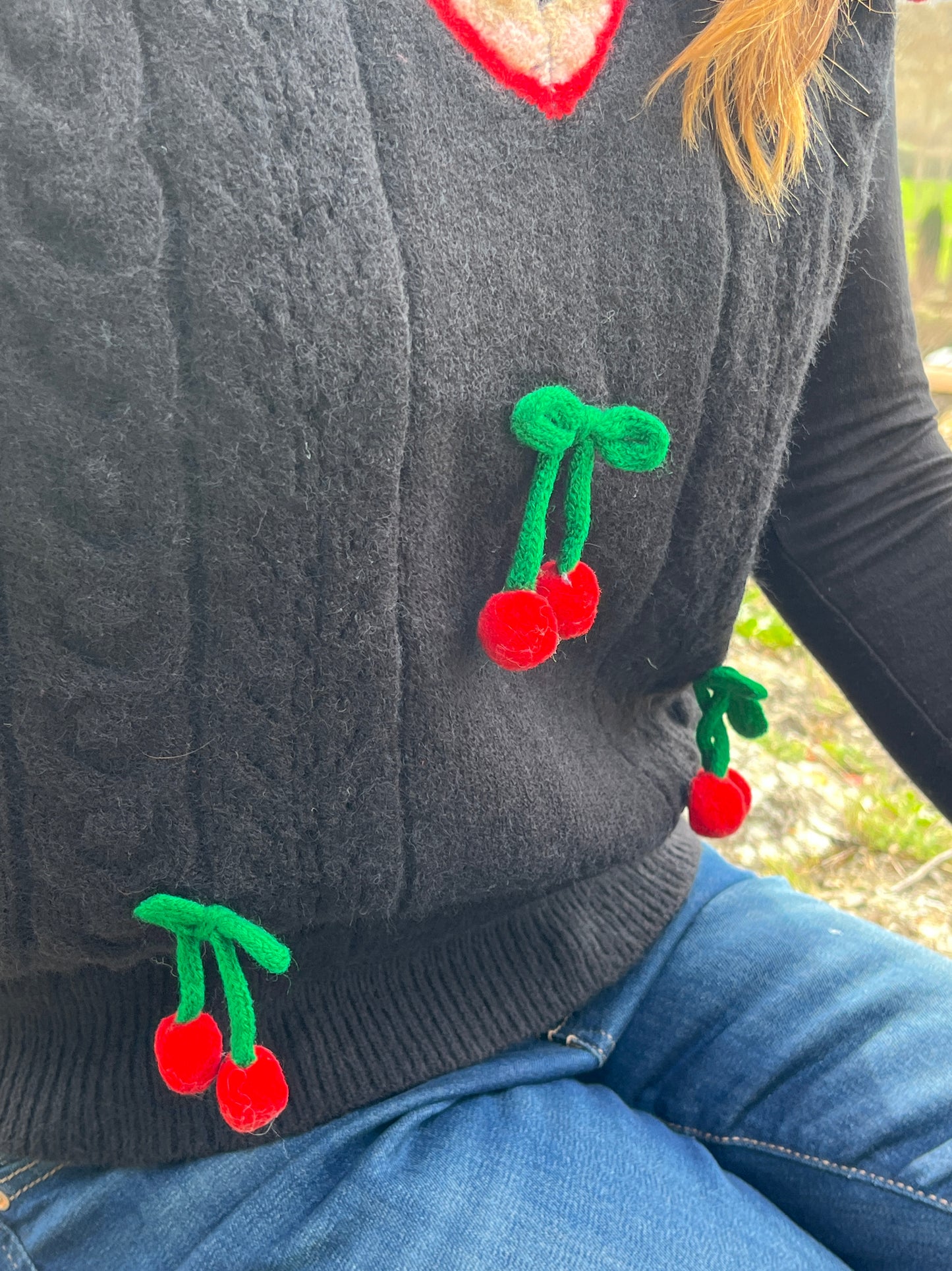 Knitted black waistcoat with cherry detail.