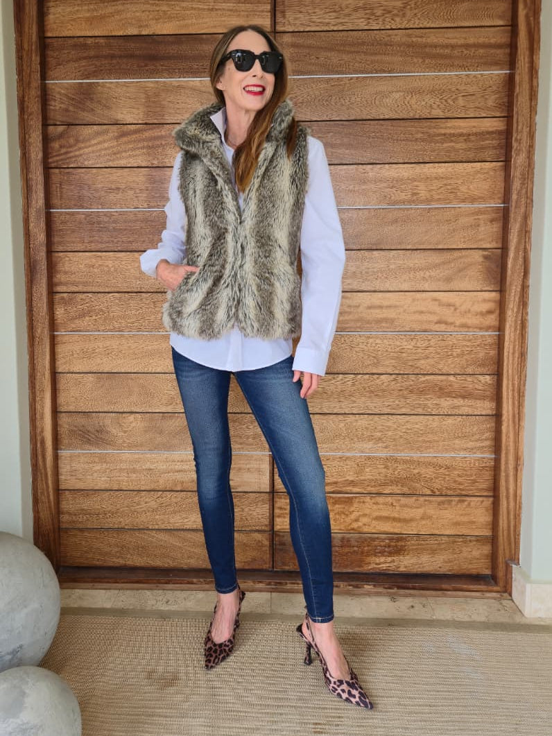 Fully lined faux fur waistcoat with side pockets and metal closures on the front.