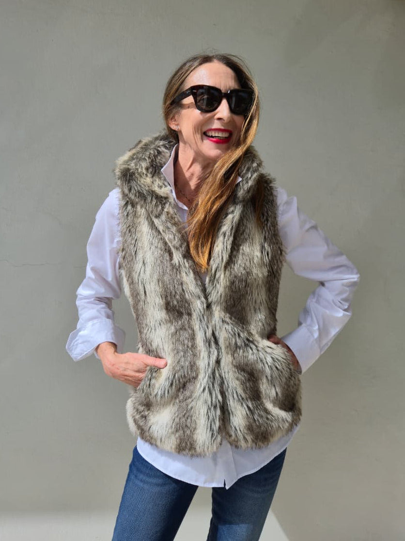 Fully lined faux fur waistcoat with side pockets and metal closures on the front.