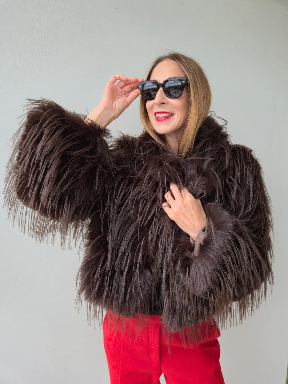 Fully lined chocolate faux fur with side pockets and metal closures on the front.