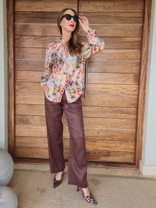 Sheer floral blouse on cream background with button/loop detail and elasticated cuff.